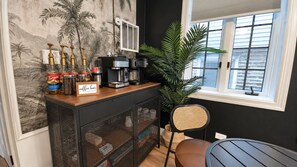 A coffee bar with a sign, a coffee machine, and various coffee products.
