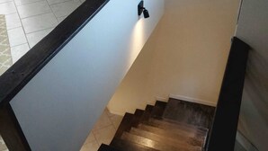 A staircase with a dark wooden handrail and a light-colored wall. - Pousada da Nega (Picarras)