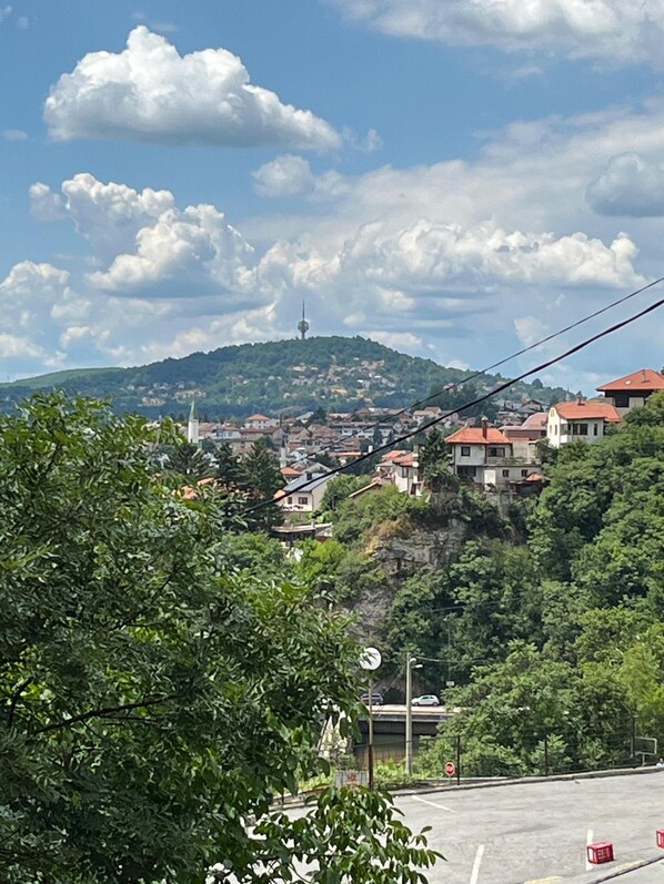 A hillside town with a prominent tower on a hill, surrounded by residential buildings and greenery. - A Peaceful and Spacious Getaway in Sarajevo (Sarajevo)
