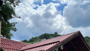 A building with a red roof, a balcony, and a window overlooking a forested area. - A Peaceful and Spacious Getaway in Sarajevo (Sarajevo)