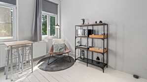 Une pièce moderne comprenant un coin repas, une chaise, une bibliothèque et un radiateur.