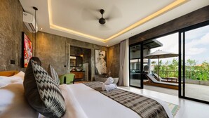 A modern hotel room with a large bed, a view of the outdoors, a ceiling fan, and a bathroom visible through an open door.