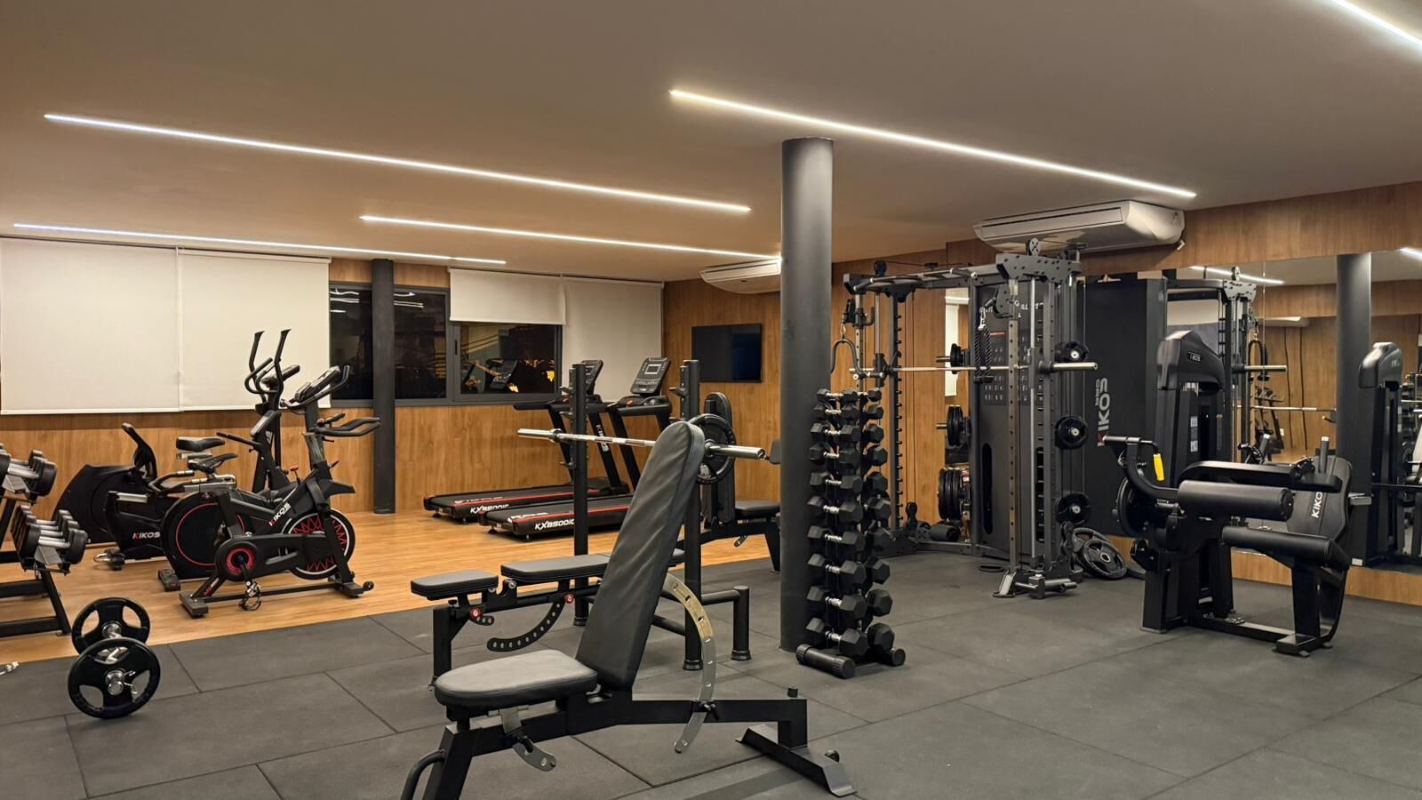 A gym with various exercise equipment including treadmills, weight machines, and free weights.