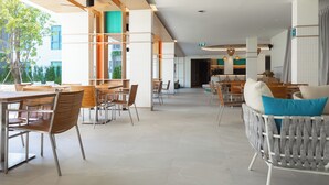 Un amplio vestíbulo de hotel con muebles modernos, una zona de estar y vistas al exterior.