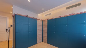 A room with a herringbone-patterned wooden floor, a blue wardrobe with a floral top, and a black floor lamp. - Luna Stay (Trieste)