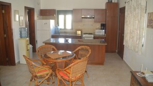 A kitchen with a dining area, wooden cabinets, a refrigerator, and a microwave. - Beach apartment stanza mare (Punta Cana)