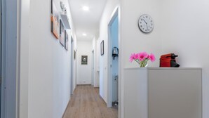 A hallway with a wooden floor, white walls, and a clock on the wall. - B&B Loggia Garbatella (Rome)
