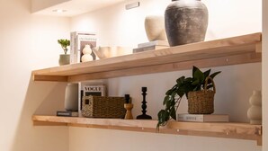 Two wooden shelves with various decorative items, including books, a vase, and a potted plant. - Documenta - With a terrace and a view of the countryside (Kassel)