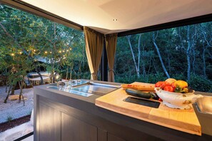 Una cocina moderna con un ventanal amplio, una encimera de madera y un cuenco de fruta.