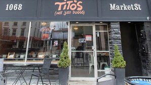 A brick building with a storefront named 'Tito's MarketSt' and a number '1068' above the entrance. - Historic Market Plaza Overlook (Wheeling)