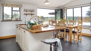 Una cocina moderna con una isla central, sillas de madera y una mesa de comedor.