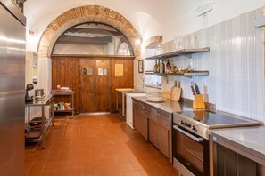 Una cocina con arco de ladrillo, electrodomésticos de acero inoxidable, armarios de madera y salpicadero de azulejos.