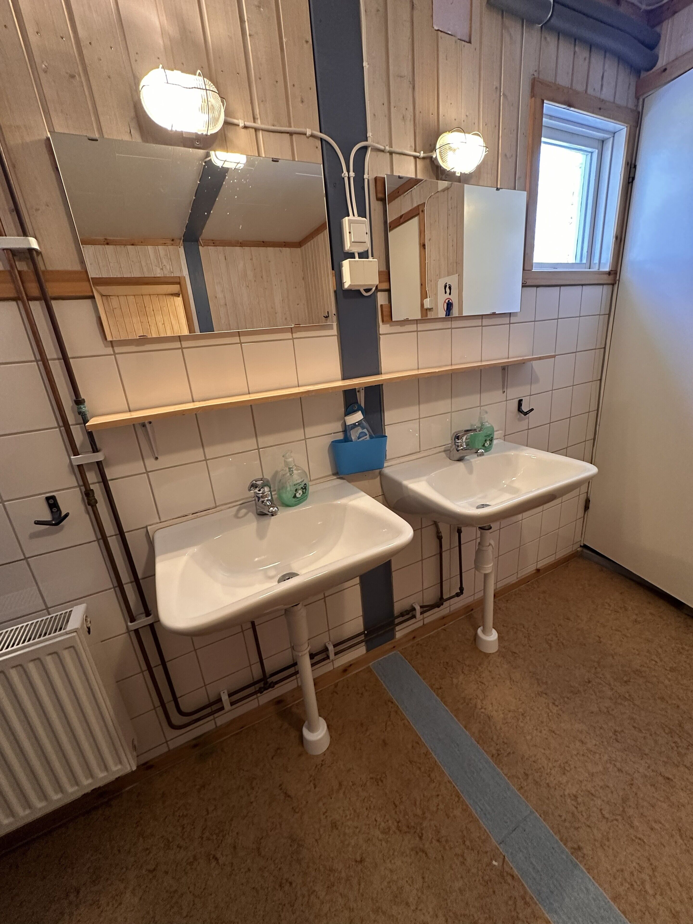 A bathroom with two sinks, a mirror, and a window.