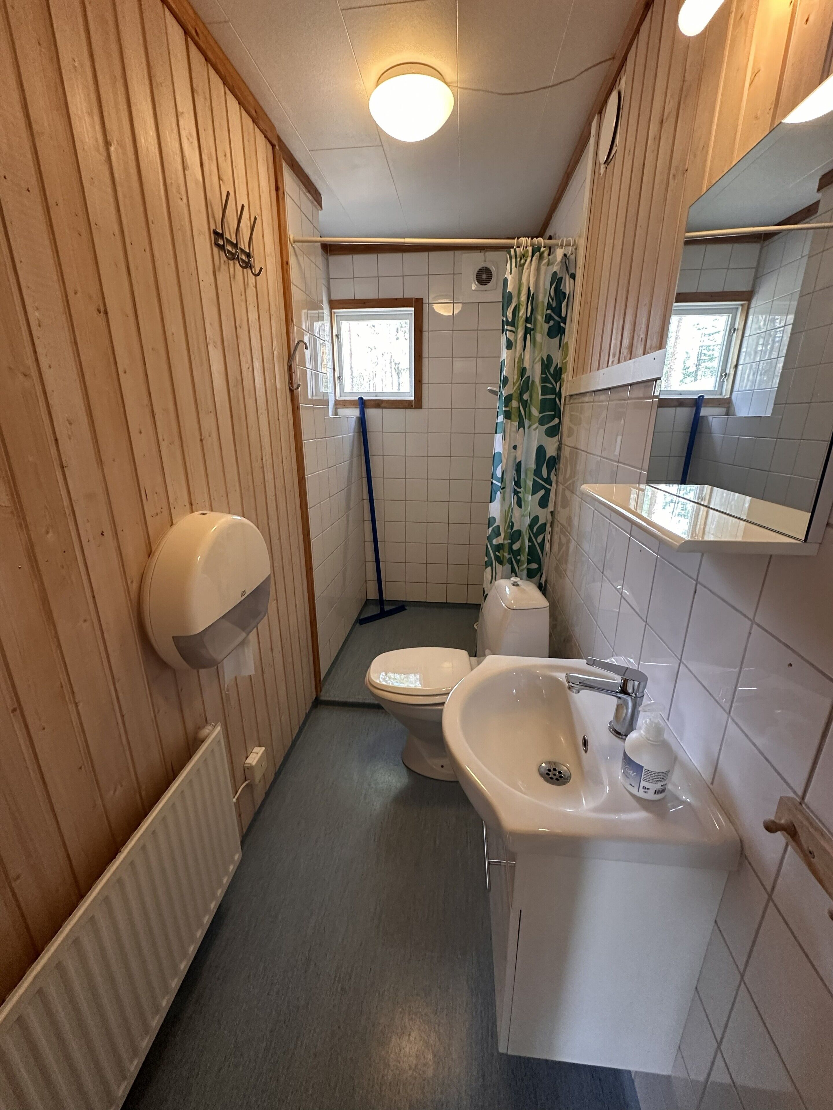 A small bathroom with a toilet, sink, and window.