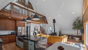 A spacious kitchen with a central island, wooden cabinets, and a built-in stove. - Sleeps 15, Stunning A-Frame Retreat with Jaw Dropping Views (Mount Pleasant)