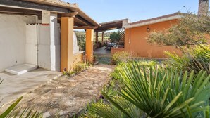 A courtyard with a covered seating area, a small pool, and surrounding vegetation. - Vacation House a few steps from the sea, Sant'Antioco  (SU)