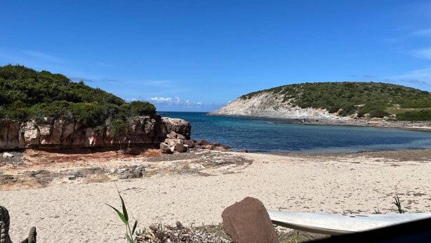 A beach with a rocky outcrop and a clear blue sky. - Vacation House a few steps from the sea, Sant'Antioco  (SU)