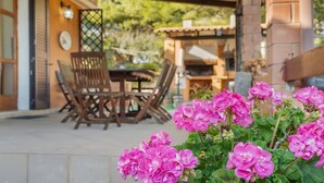 An outdoor patio with wooden furniture and a brick wall. - Vacation House a few steps from the sea, Sant'Antioco  (SU)