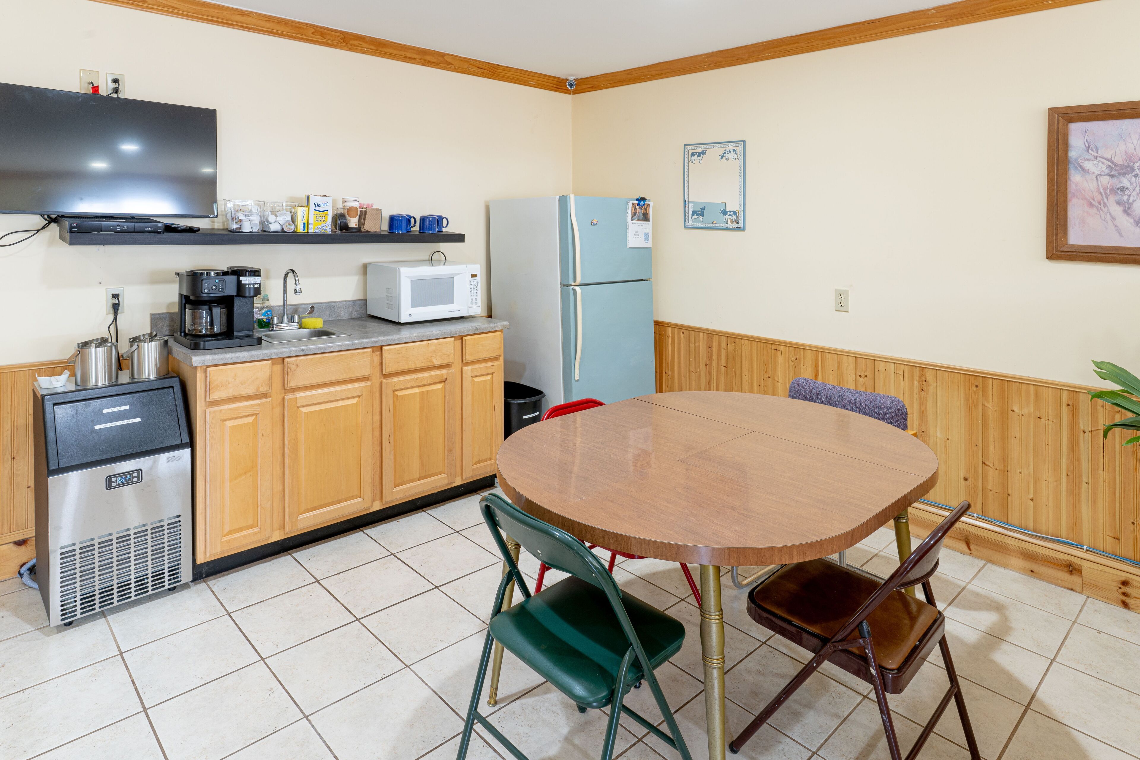A compact kitchen with a microwave, coffee maker, and a refrigerator.