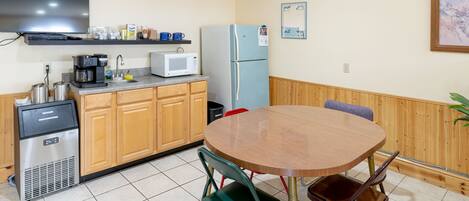 A compact kitchen with a microwave, coffee maker, and a refrigerator.
