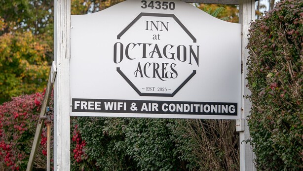 A sign for Inn at Octagon Acres with amenities including free wifi and air conditioning.