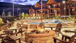 A lodge with a fire pit, outdoor seating, and a pool area.