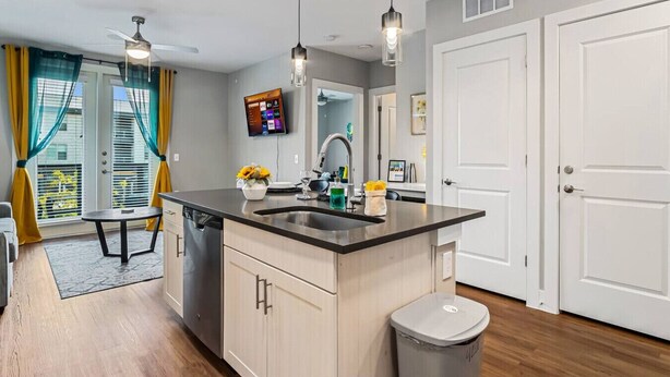 A modern kitchen with a central island, a dishwasher, and a trash can. - Cozy Luxury 1bd | Pool+Gym+Stockyards+Free Parking (Fort Worth)