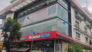 A building with a sign for 'Reliance Digital' and 'Rooms Available'.