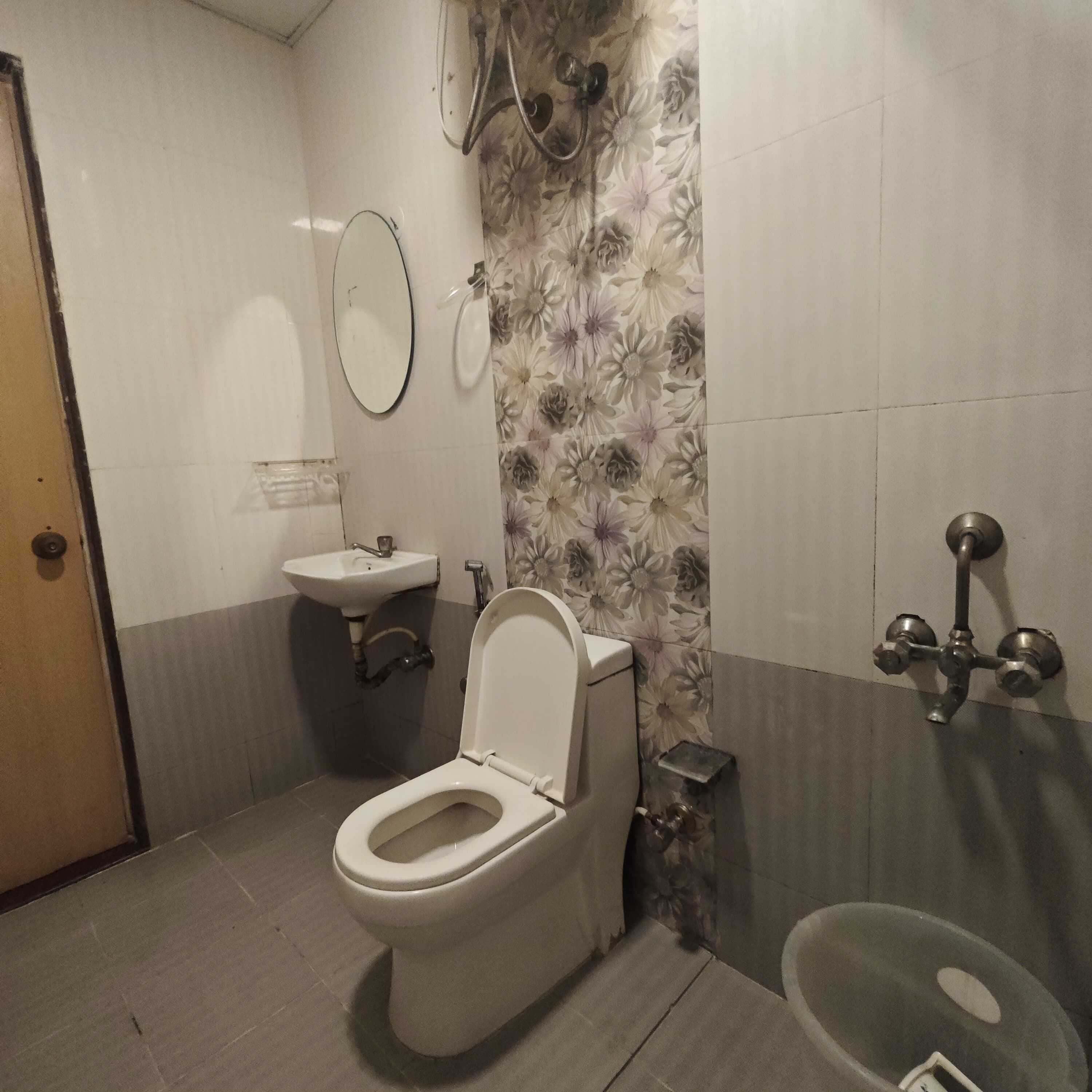 Une salle de bain comprenant des toilettes, un lavabo, une douche et un miroir.