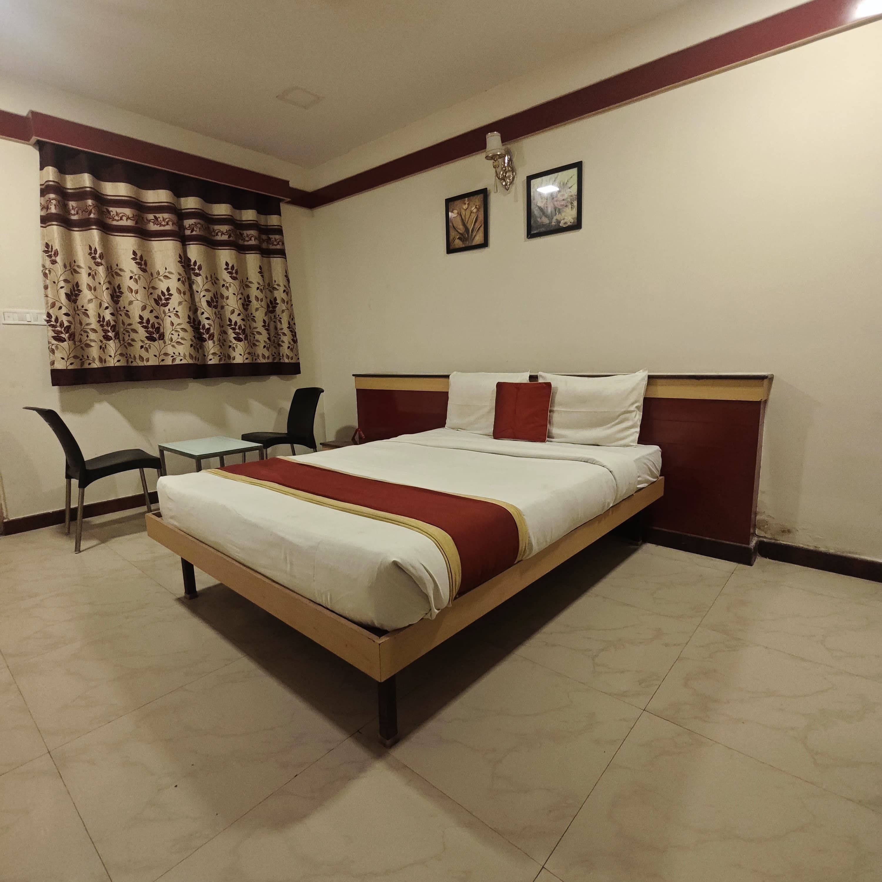 A bedroom with a bed, a desk, and two chairs.