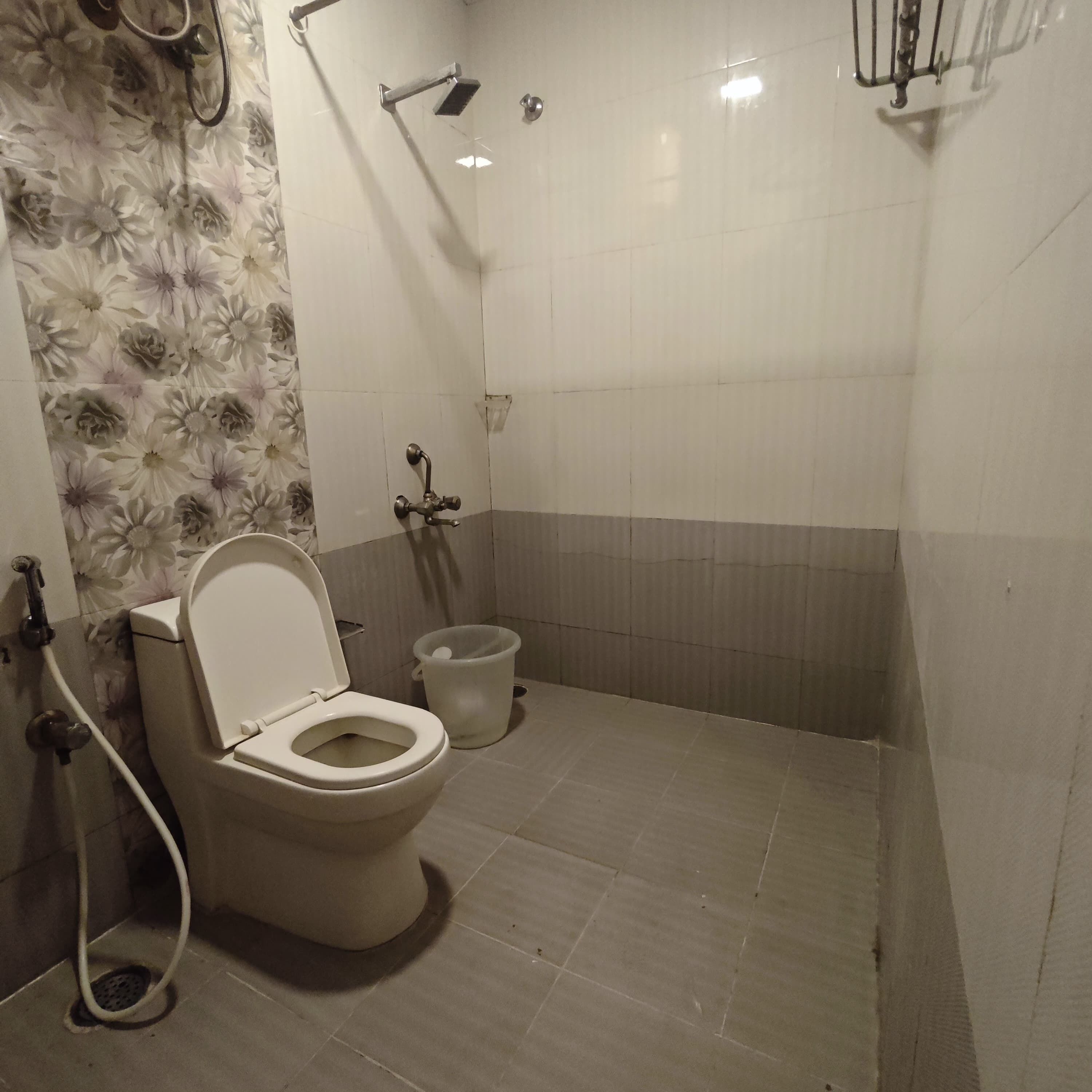 Une salle de bain équipée de toilettes, d’une douche et d’un bidet.