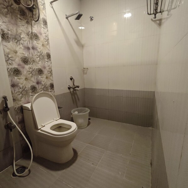 A bathroom with a toilet, a shower, and a bidet.