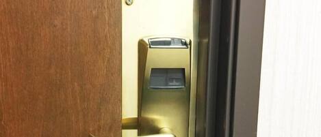 A door with a brass handle and a keycard reader.