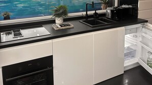 A modern kitchen with a view of a swimming pool and a cityscape. - Jas Pipera Studio &Private Pool (Voluntari)