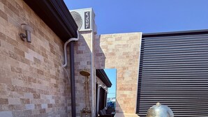 A building exterior with a brick facade, a Tesla logo, and a golden statue of a gorilla. - Jas Pipera Studio &Private Pool (Voluntari)