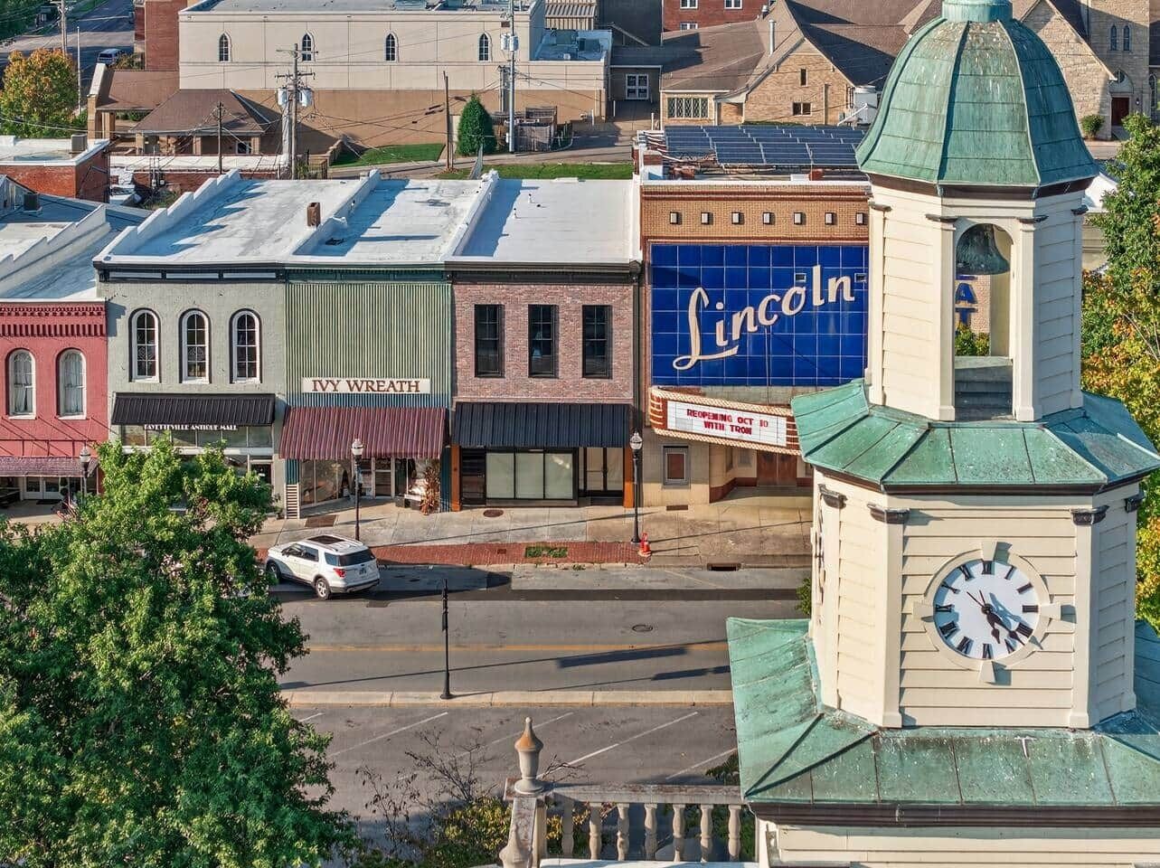 Ein Stadtplatz mit einem Glockenturm, einem Lincoln Theater und einem alten Gebäude mit dem Schriftzug "Ivy Wreath".