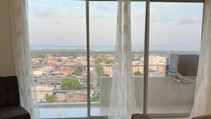 A living room with a large window overlooking a cityscape. - Apartment 5 minutes from the Sea and Downtown Airport (Cartagena de Indias)