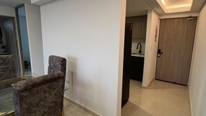 A modern kitchen with a dark countertop, a wooden door, and a tiled floor. - Apartment 5 minutes from the Sea and Downtown Airport (Cartagena de Indias)
