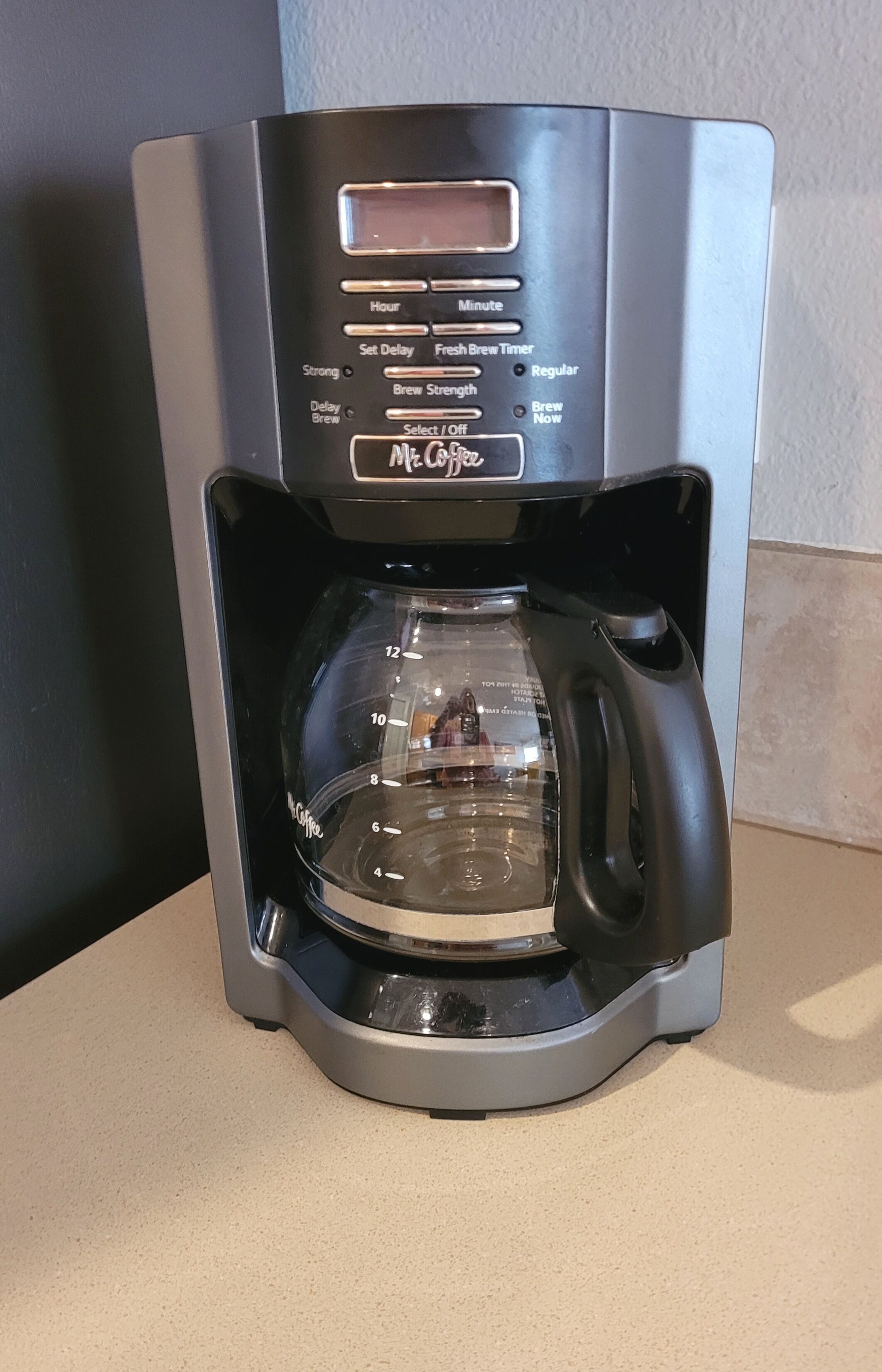 Eine Kaffeemaschine mit digitaler Anzeige, Timer-Einstellung und Kaffeekanne.