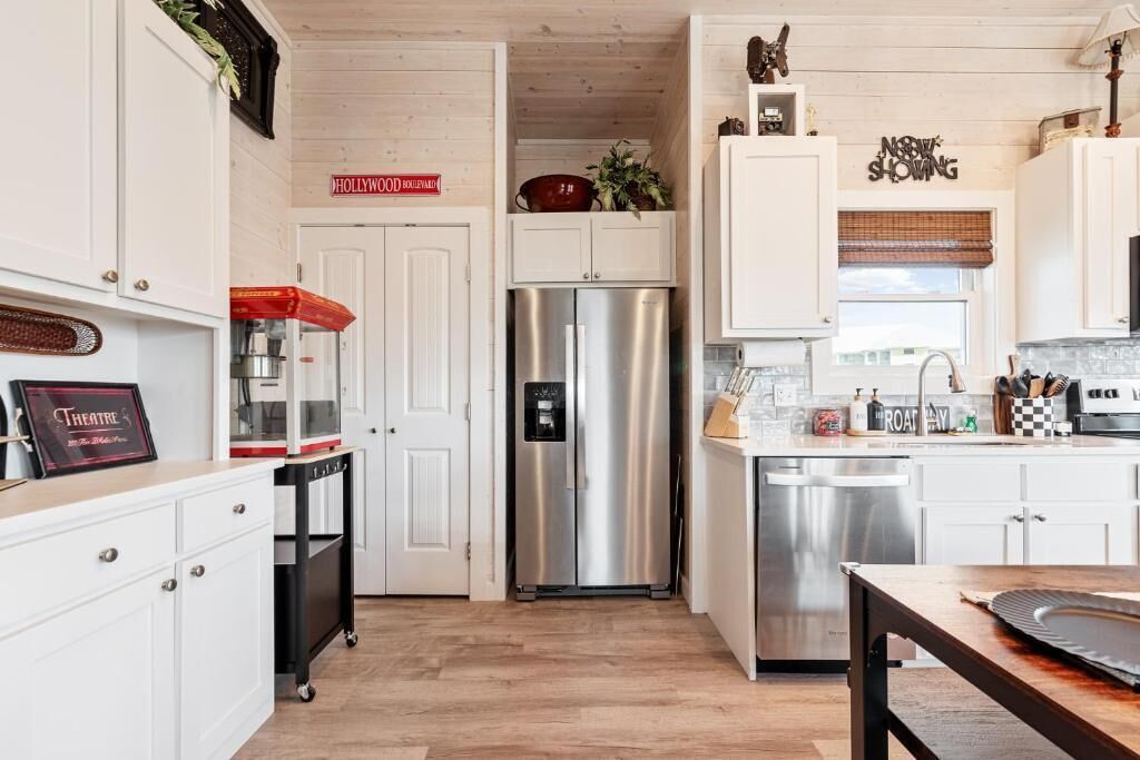 A kitchen with white cabinets, a stainless steel refrigerator, and a sign that reads "HOLLYWOOD BOULEVARD."