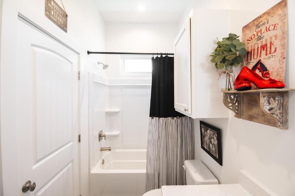 A bathroom with a bathtub, a toilet, a sink, and a shower curtain.