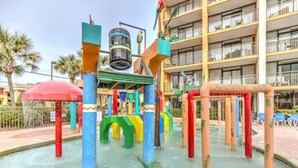 Een speelgedeelte met water, kleurrijke constructies en een zwembad.