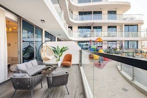 Ein modernes Interieur mit Balkon, einer Sitzecke und einem Spielbereich für Kinder.