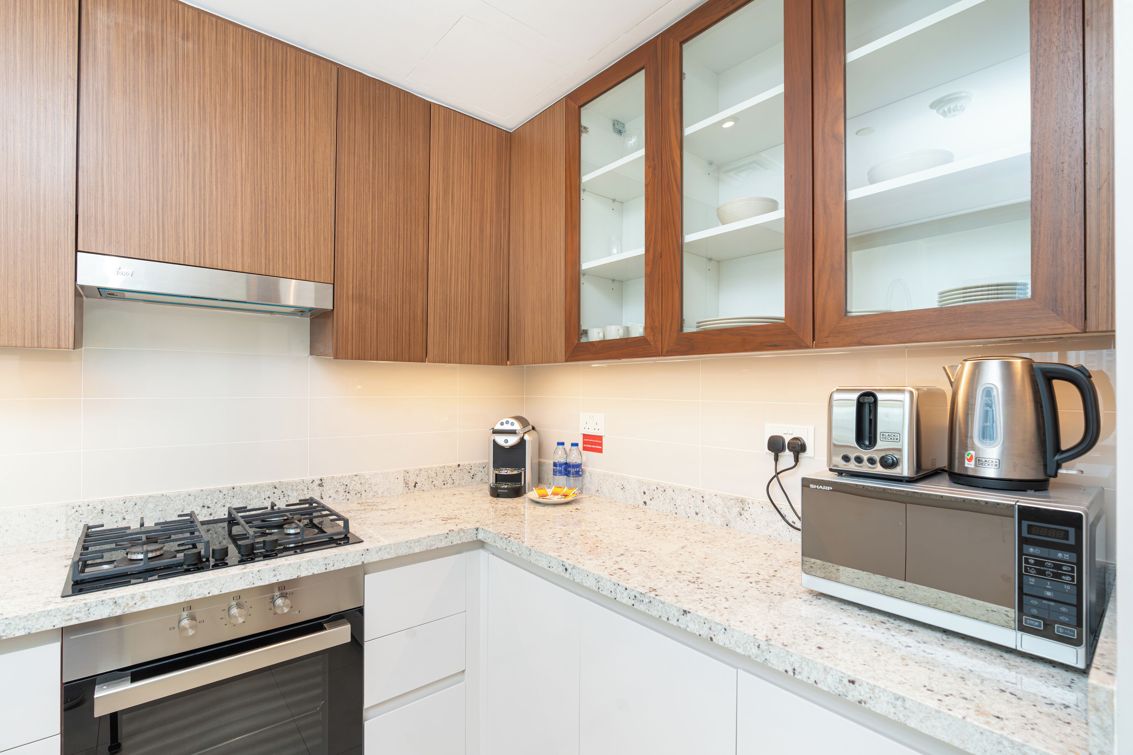 A kitchen with wooden cabinets, a stainless steel stove, a microwave, and a coffee maker.