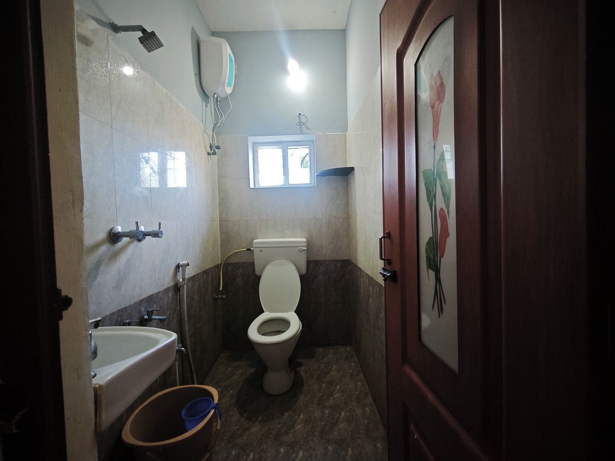 Een kleine badkamer met toilet, wastafel en douche.