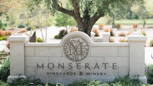 A sign for Monserate Vineyards & Winery with a tree in the background.
