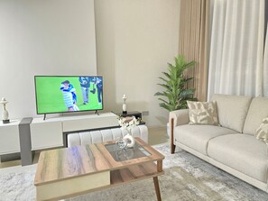 Apartamento de lujo, balcón, vistas a la ciudad | Zona de estar | Smart TV de 65 pulgadas con canales digitales, servicios de streaming
