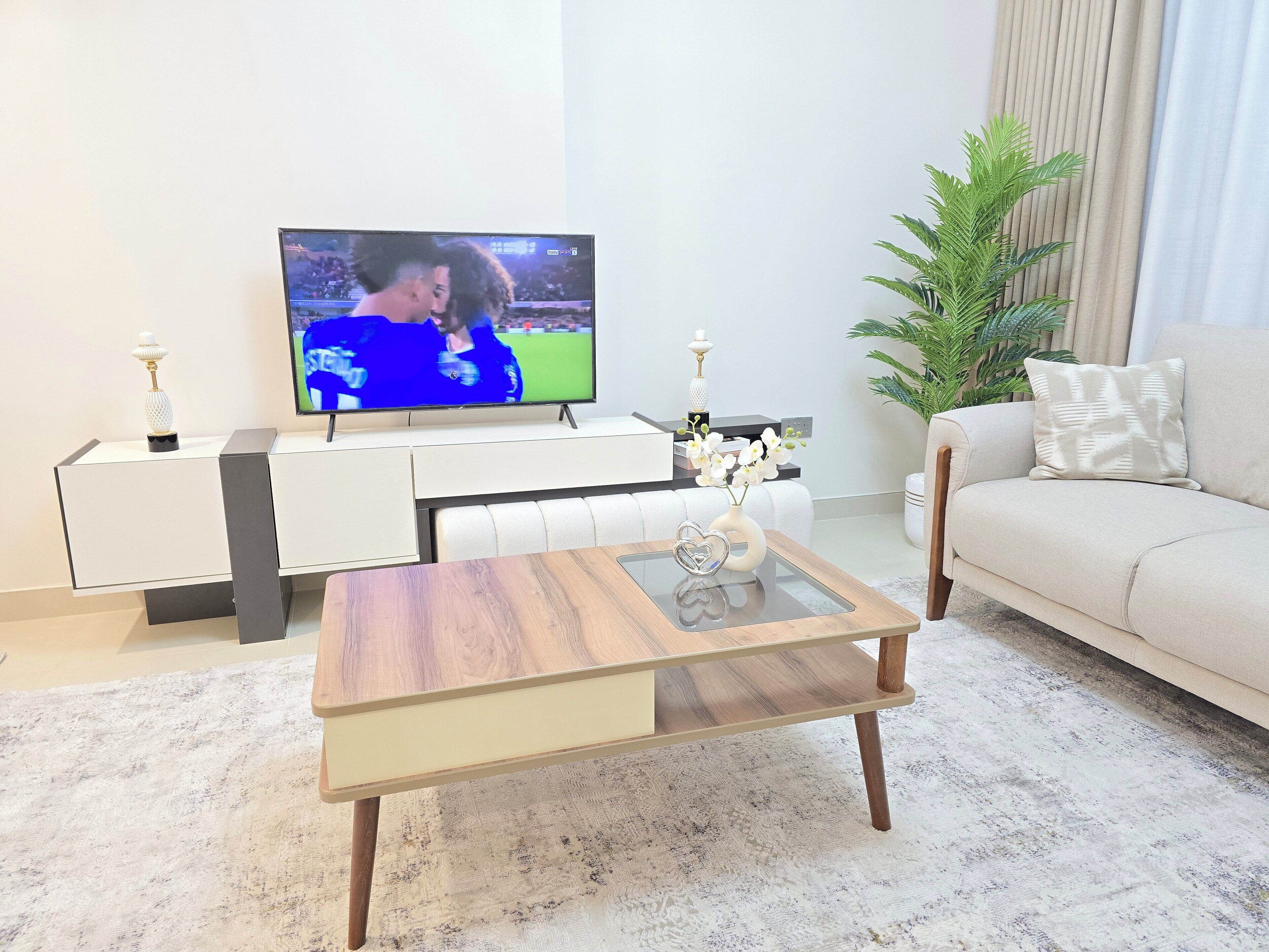 Departamento de lujo, balcón, vista a la ciudad | Área de sala de estar | Smart TV de 65 pulgadas con canales digitales y servicios de streaming 