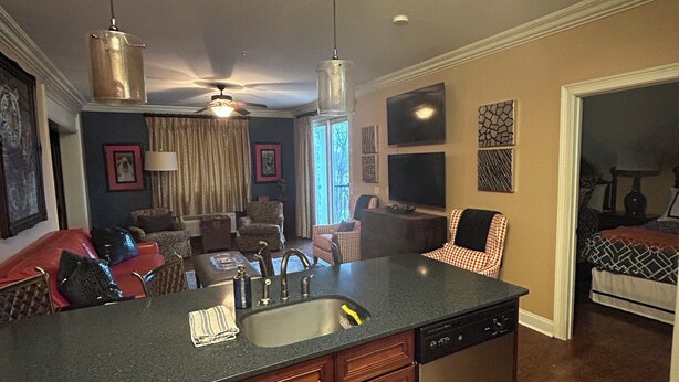 A kitchen with a central island, wooden cabinets, and a dishwasher. There is a dining area with a couch and chairs. -  3-BR Condo Auburn, AL  Walking distance and minutes from downtown and campus (Auburn)
