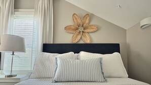 Un dormitorio con cama, lámpara y un adorno en la pared.